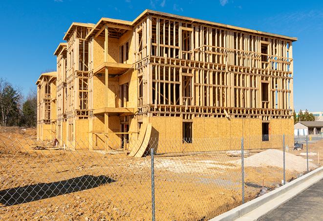 a construction site enclosed by temporary chain link fences, ensuring safety for workers and pedestrians in Gurnee, IL